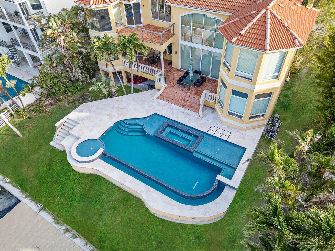 Aerial view of a Pool Perfection custom concrete pool and paver deck in a Tampa Bay backyard