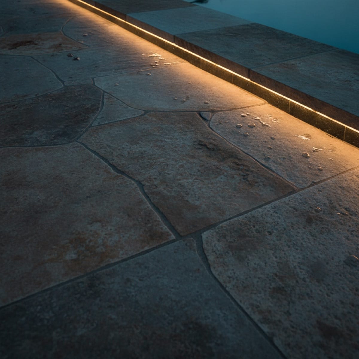 Close-up of expertly finished pool stonework at dusk, tangible proof behind the real numbers