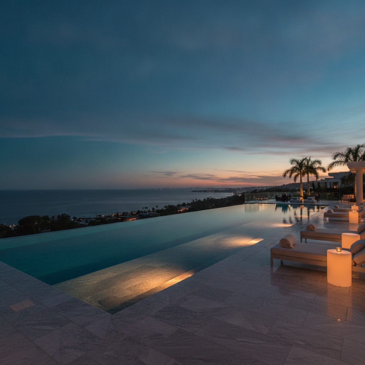 Luxury infinity-edge pool at dusk, a tangible asset representing real return on marketing spend